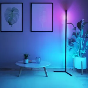 Lite Bulb Moments smart hörnlampa med slimmad svart design som sprider blått, cyan och lila stämningsljus i ett hörn av rummet.
