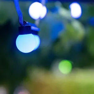 Lite Bulb Moments ljusslinga med glober som lyser blåvitt på en svart kabel, med suddiga lampor i bakgrunden