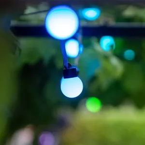 Lite Bulb Moments ljusslinga med klotlampor som lyser blåvitt mot en suddig grön bakgrund
