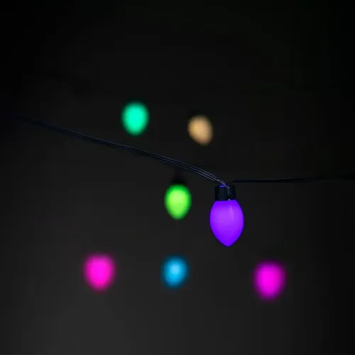 Smart lyskjede med dråpeformede lyskuler på svart kabel; nærbilde av lilla lampe i fokus, fargede lamper uskarpe i bakgrunnen.